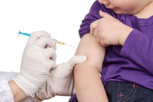 Ребенку ставят в руку вакцину